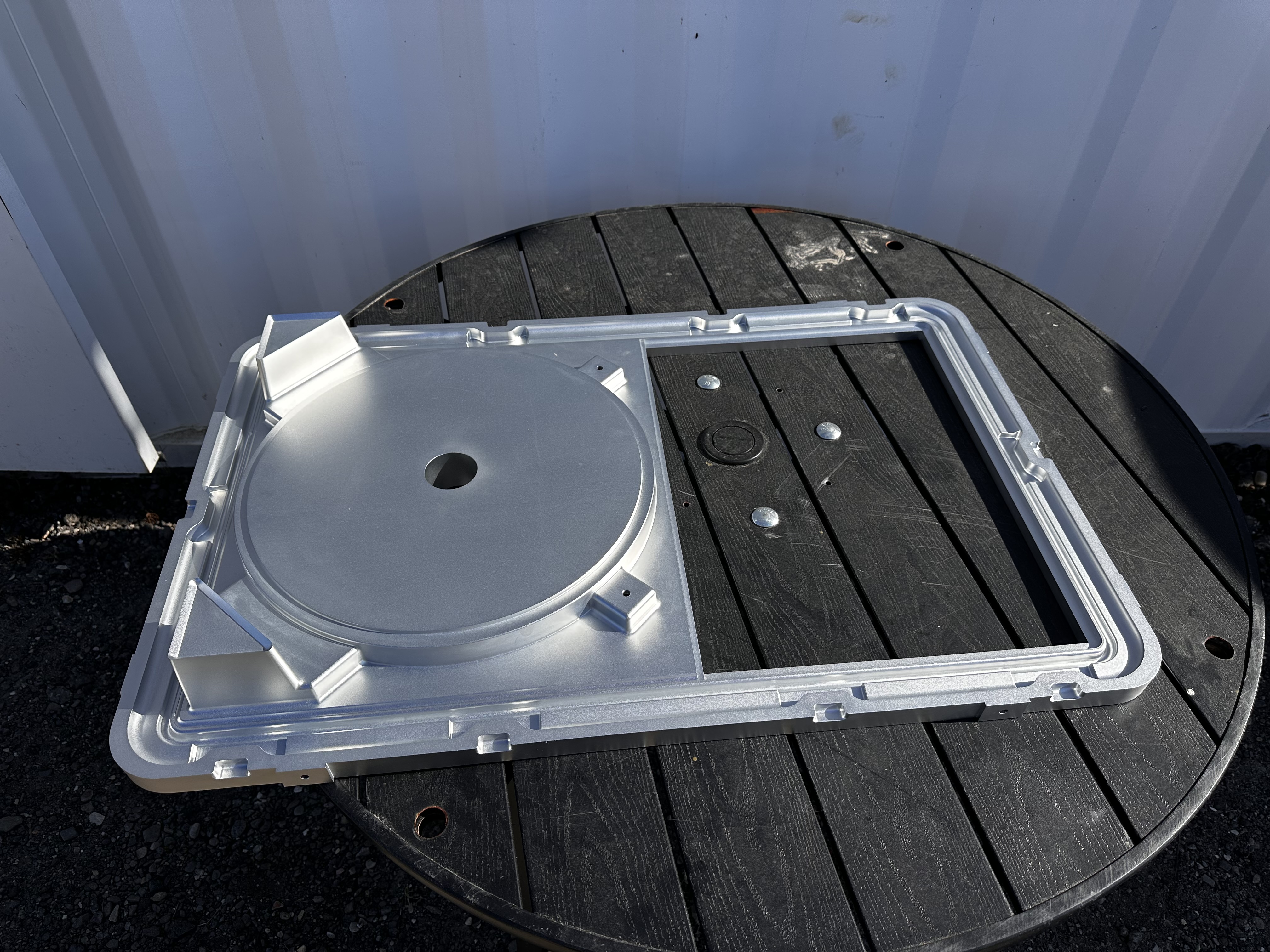Rotomolding mold hardware assembly with machined components arranged for product presentation.